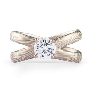 very unique mokume gane engagement style ring, bands are doubled and criss crossed to make an x shape with a prong set diamond at the center