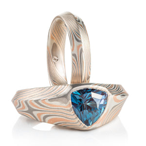mokume gane ring set, both have an angular beveled profile, both made of combination of red gold palladium and silver, one ring has a large triangular alexandrite set into it
