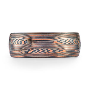 mokume gane patterned ring, layers of red gold palladium and oxidized silver. The pattern resembles flowing water and rippling pools.