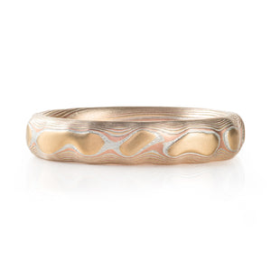 red gold, yellow gold and silver carved mokume ring. hand forged and hand carved. looks like  gold islands floating above silver and red lines like a river of metal 