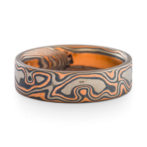 Mokume Gane flat profile ring or wedding band made by arn krebs, in woodgrain pattern and embers palette, the embers palette is red gold palladium and silver, this ring also has an added palladium top sheet making gray the primary color in the ring