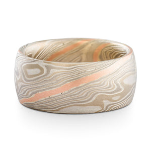 Mokume gane ring or wedding band made by arn krebs, 9mm wide band, twist pattern and smoke palette, the smoke palette is white gold palladium and silver, and this ring has an added red gold stratum layer running through the twist pattern