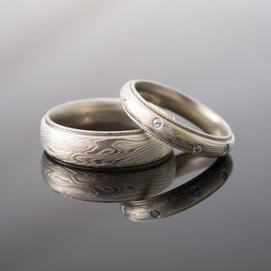 classic vintage feeling mokume gane ring set with tiny flush set moissanites and milgrain rails on top and bottom edges