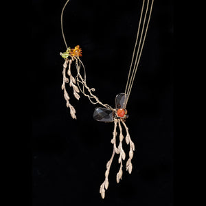 A stunning piece featuring cast bronze budding twigs with carnelian, peridot, and citrine with cascading gold filled chain.