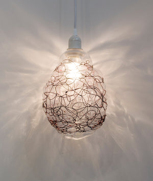 Clear blown glass pendant light accented by woven blackened copper wire scribble lines all over. Lighting, home decor, interior design