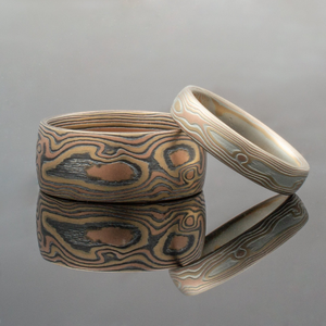 set of contrasting woodgrain pattern mokume gane rings, one with oxidized silver for a darker more saturated look