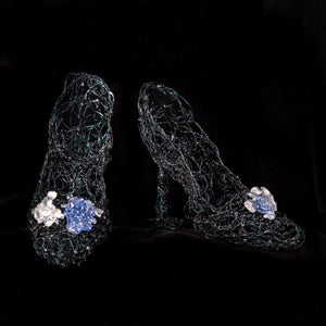 Black wire sculpture of a pair of womens heels with blue and clear glass clusters on the toes