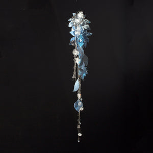 White paper leaves with blue paint in various leaf species shapes hanging in a long cluster with glass beads on silver chains